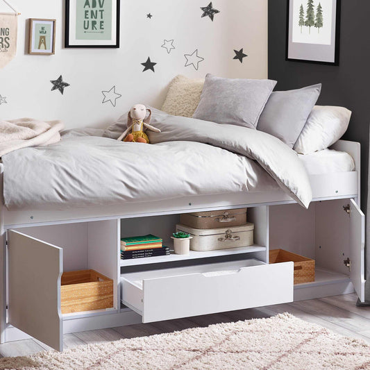 Children's bedroom with a bed that has storage compartments under it.