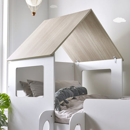Apex roof and window detail of this children's mid sleeper house bed with pale wood styling